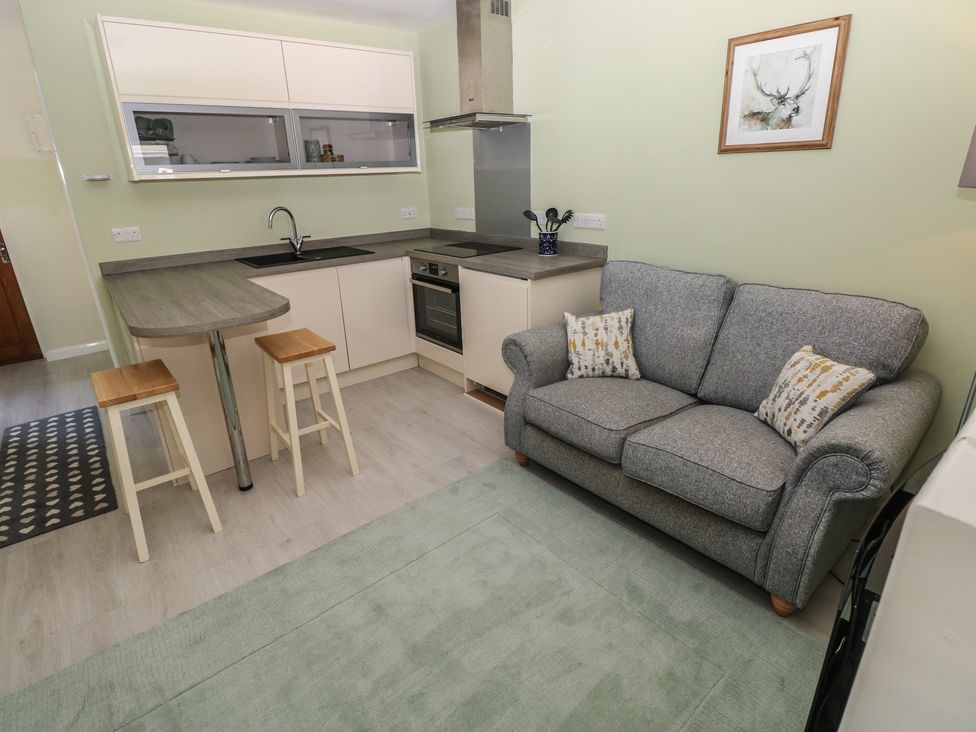 A kitchen with a sofa and bar stools at Sea Haze in Tenby