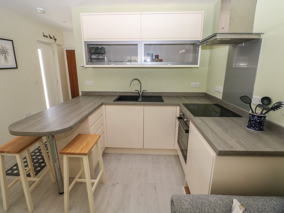 A kitchen with a sink and stove at Sea Haze in Tenby