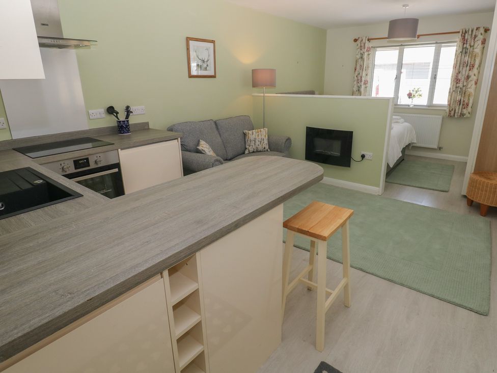 A kitchen with a bar counter and sofa at Sea Haze in Tenby