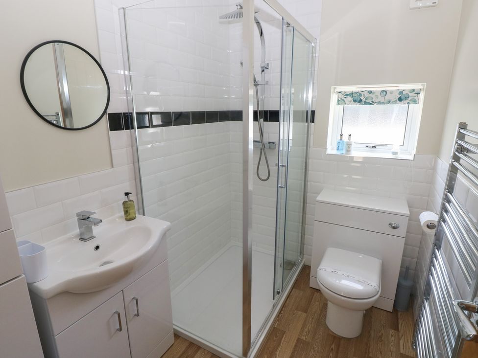 A bathroom with a shower, toilet, and sink at Sea Haze in Tenby