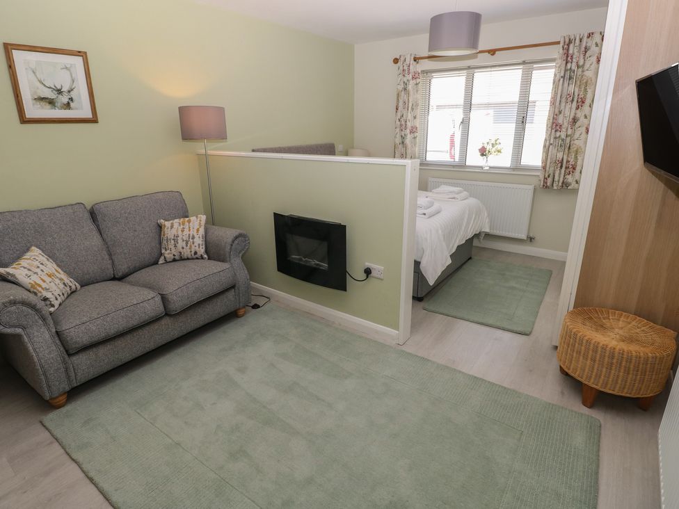 A living room with a sofa and fireplace at Sea Haze in Tenby