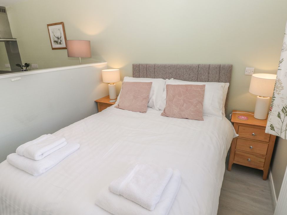 A bedroom with a bed and bedside tables at Sea Haze in Tenby