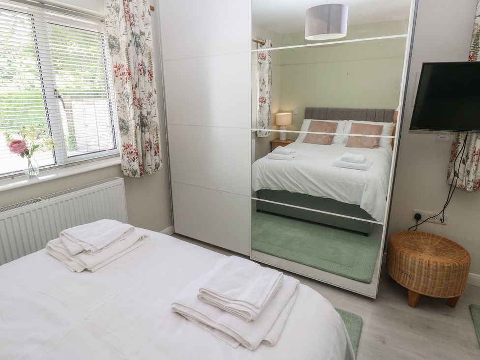 A bedroom with a bed and wardrobe at Sea Haze in Tenby
