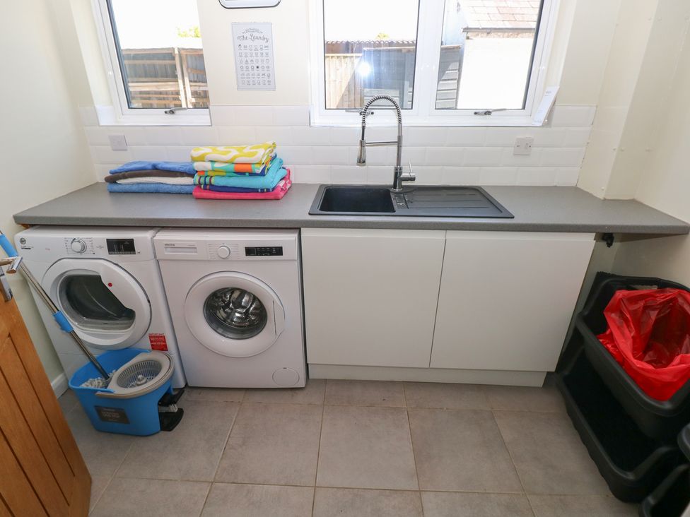 A laundry room with a washing machine and sink at Sea Haze in Tenby