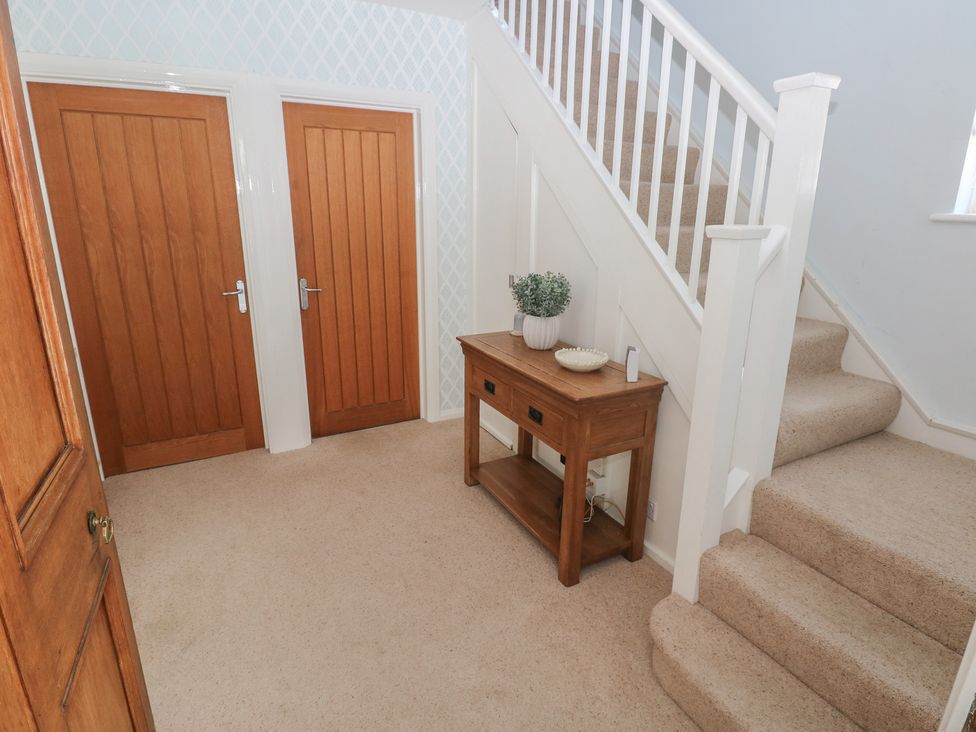 A hallway with a table and stairs at Sea Haze in Tenby