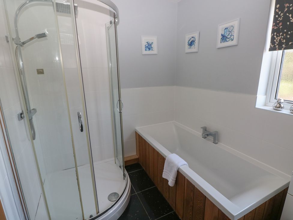 A bathroom with shower and bathtub at Sea Haze in Tenby