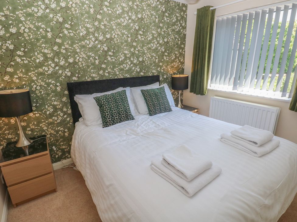 A bedroom with a bed and nightstands at Sea Haze in Tenby