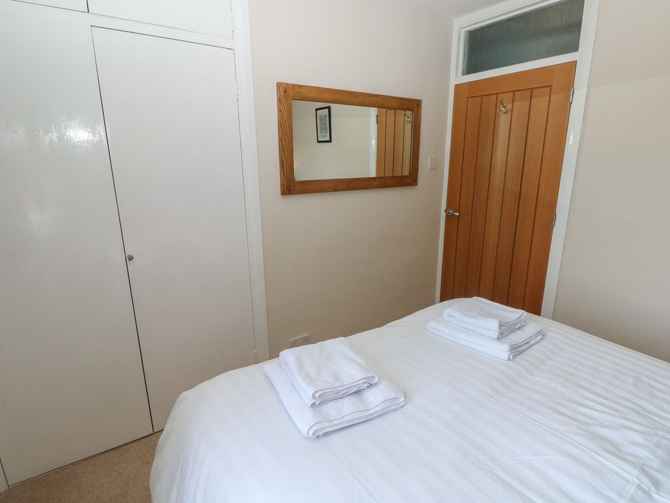 A bedroom with a bed and towels at Sea Haze in Tenby