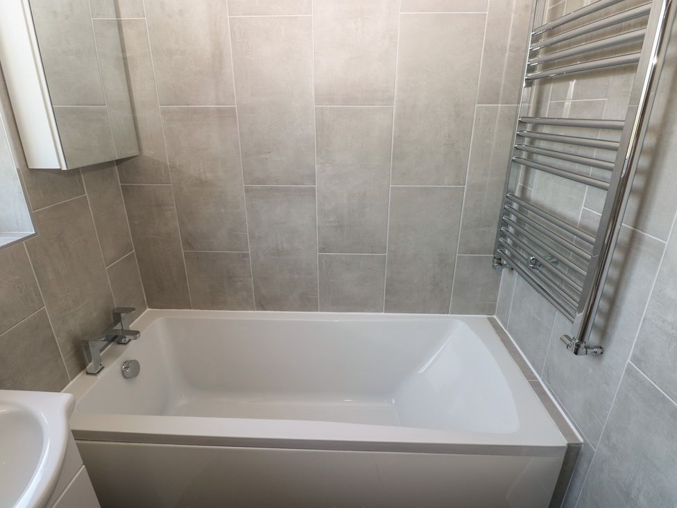 A bathroom featuring a bathtub and towel radiator at Sea Haze in Tenby