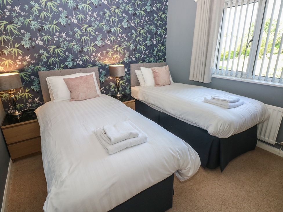 A bedroom with two single beds and lamps at Sea Haze in Tenby