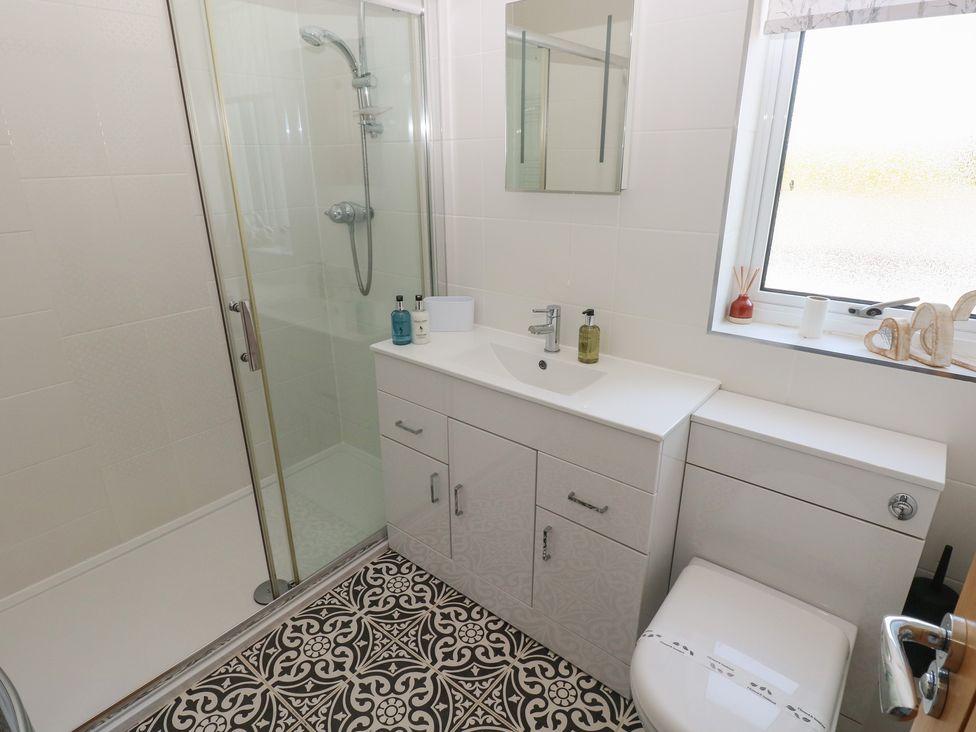 A bathroom with a shower, sink, and toilet at Sea Haze in Tenby