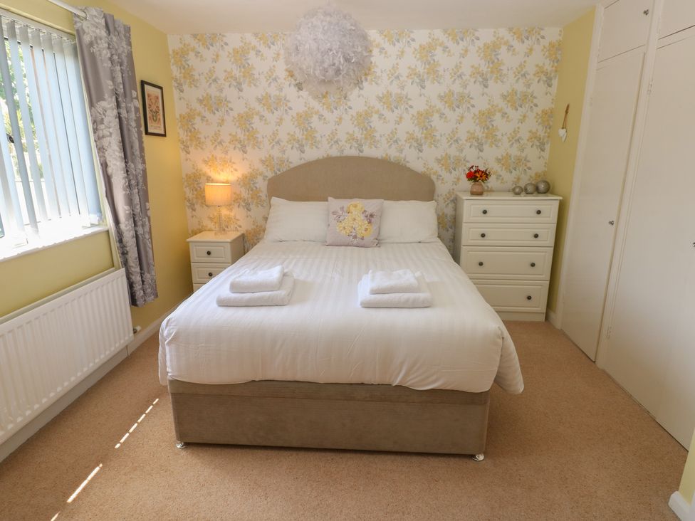 A bedroom with a bed and bedside lamp at Sea Haze in Tenby