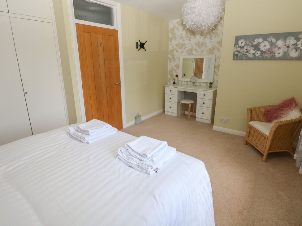 A bedroom with a bed and vanity at Sea Haze in Tenby