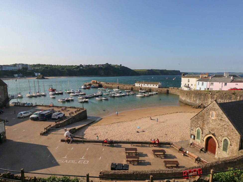 A beach with boats in the water and buildings at Sea Haze in Tenby