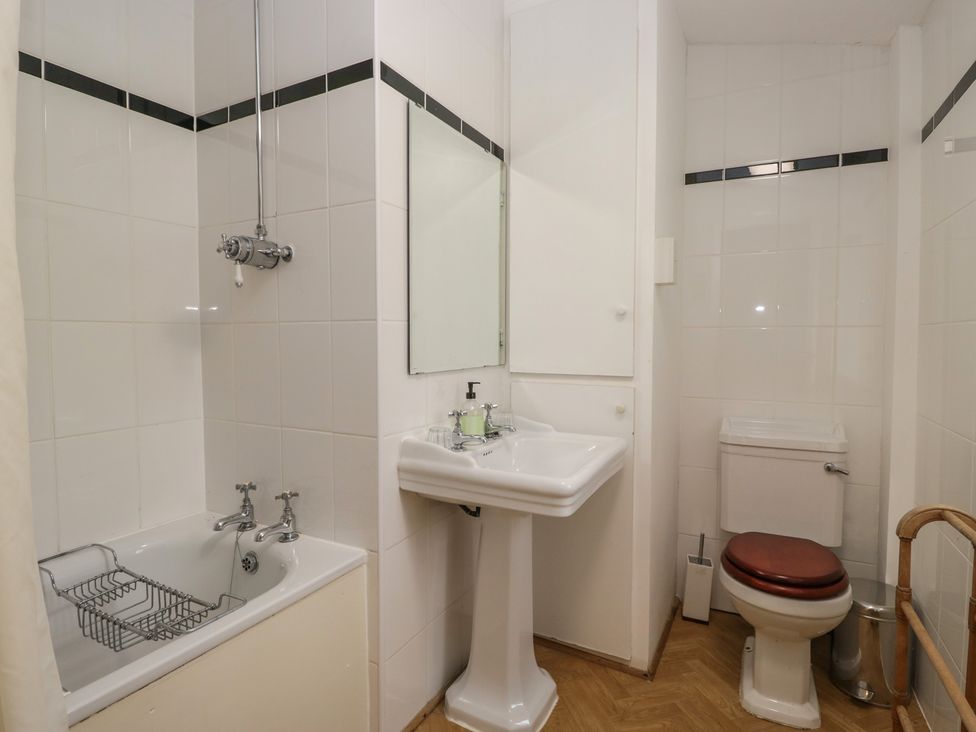 A bathroom with a bathtub, sink, and toilet at The Old Kitchen in Cartmel