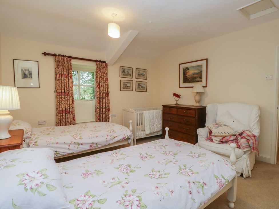 A bedroom with two beds and a window at The Old Kitchen in Cartmel
