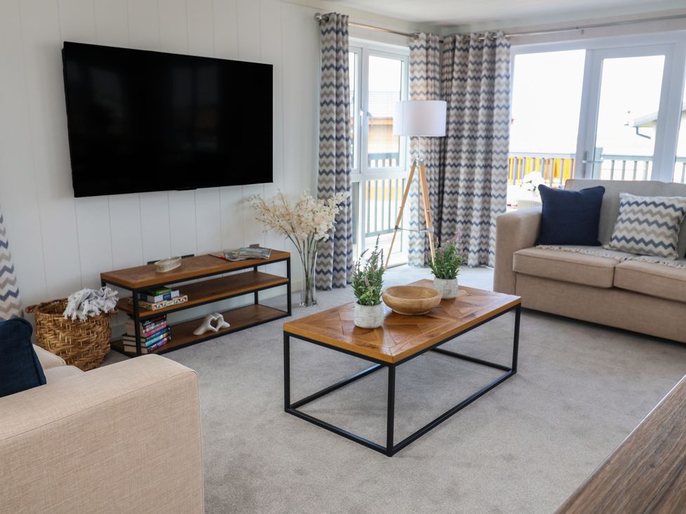 A living room with a television and sofa at Lodge 1 in Norwich