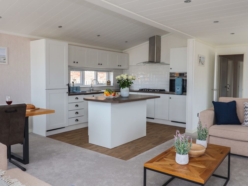 A kitchen and living area with an island and dining area at Lodge 1 Norwich