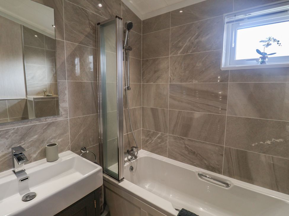 A bathroom with a sink and a bath tub at Lodge 1 Norwich