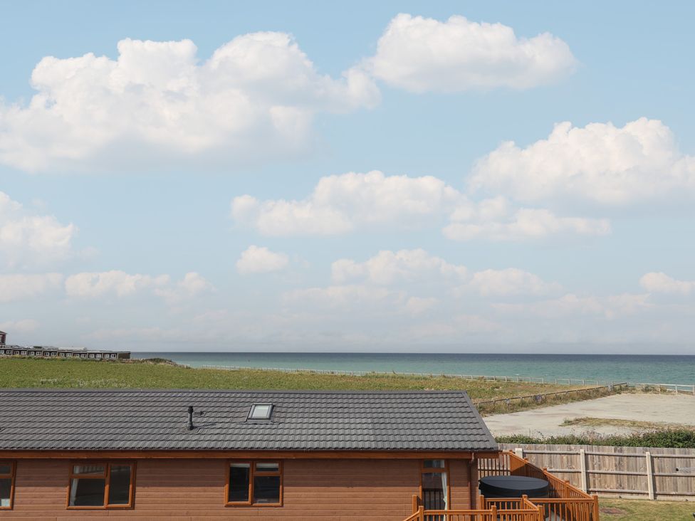 A cabin with a deck overlooking the ocean at Lodge 1 in Norwich