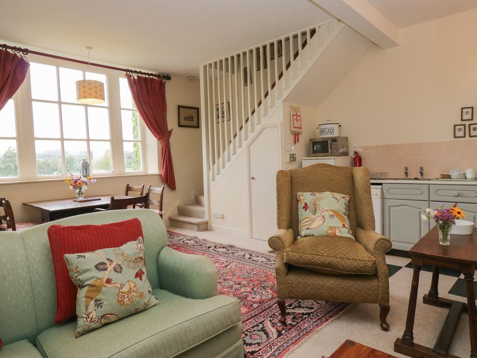 A living room with a sofa and table at Huntsman's Cottage in Cartmel