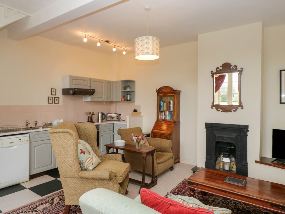 A living room with a sofa and coffee table at Huntsman's Cottage in Cartmel