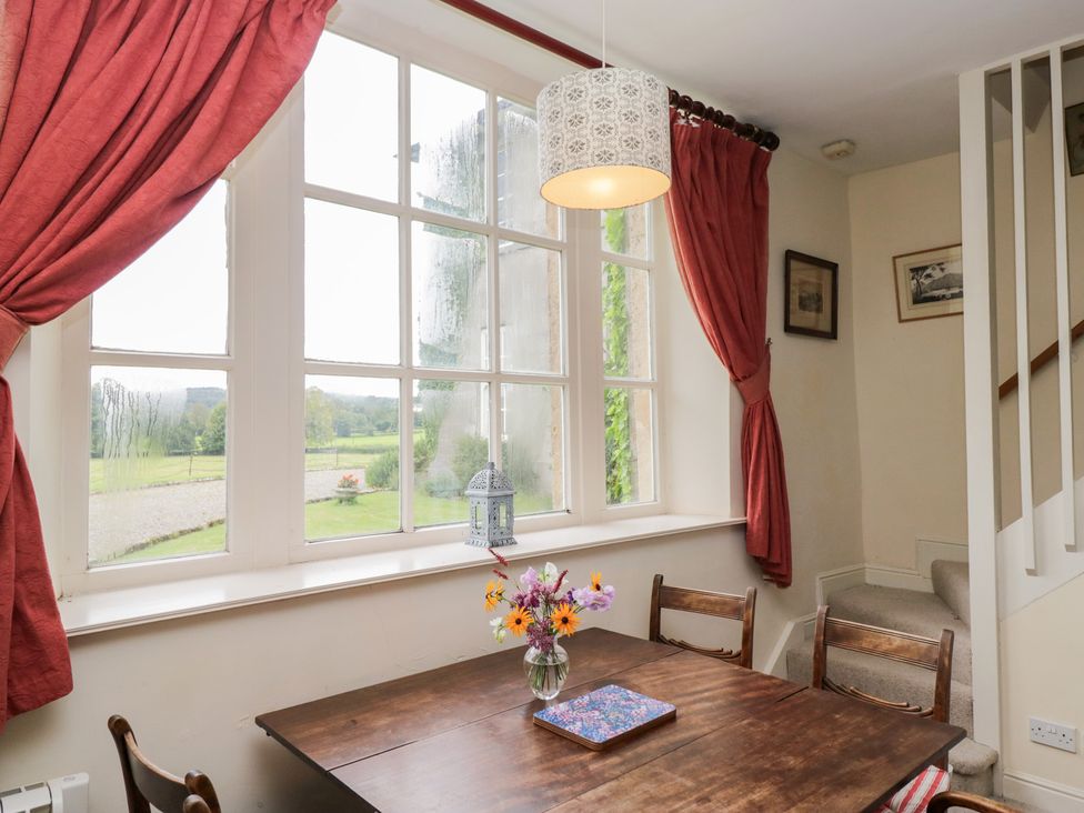 A dining room with a table and chairs at Huntsman's Cottage in Cartmel