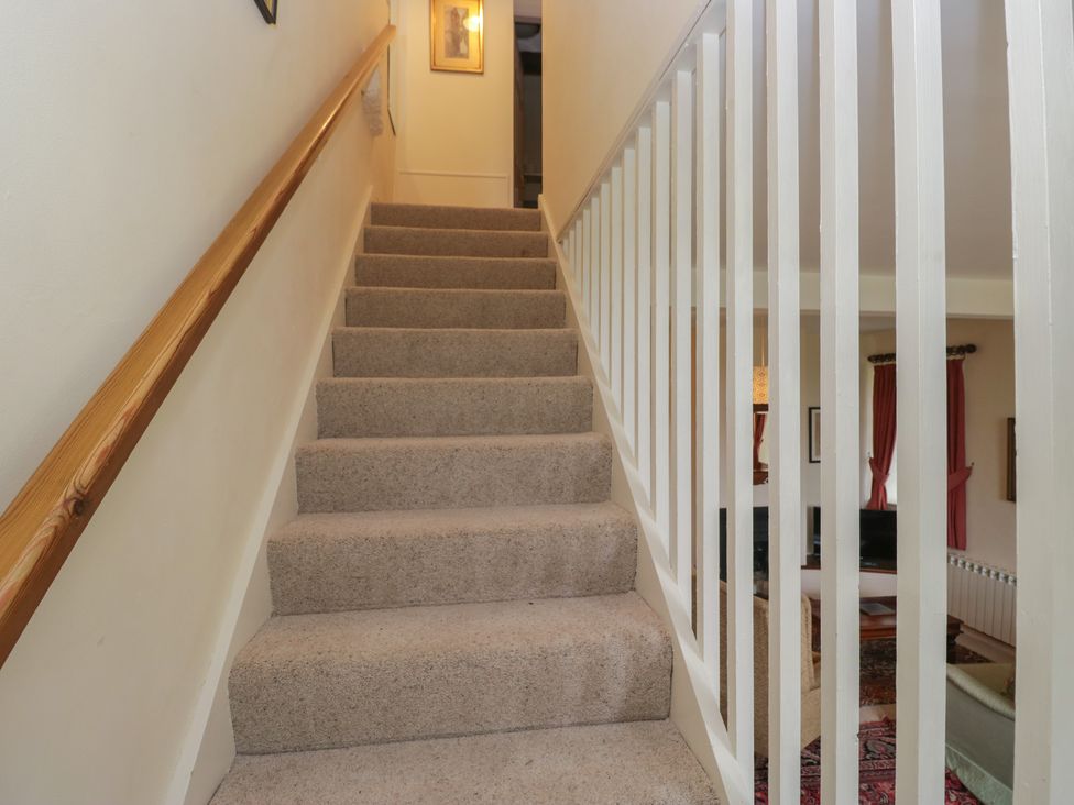 A staircase with a handrail at Huntsman's Cottage in Cartmel