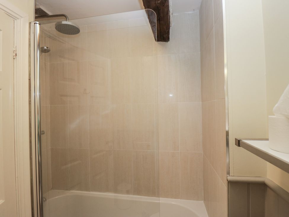 A bathroom with a shower and bath at Huntsman's Cottage in Cartmel