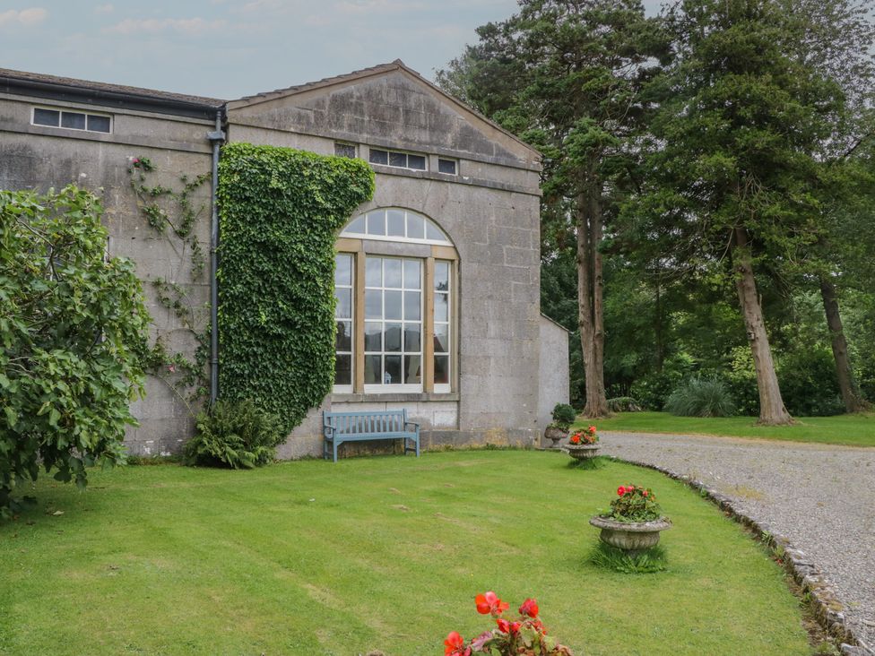 An exterior view of a building with a window and flowers at Huntsman's Cottage in Cartmel