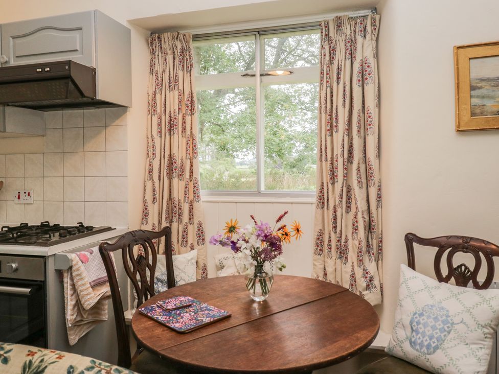 A kitchen with a table and chairs at The Laundrymaid's Cottage in Cartmel
