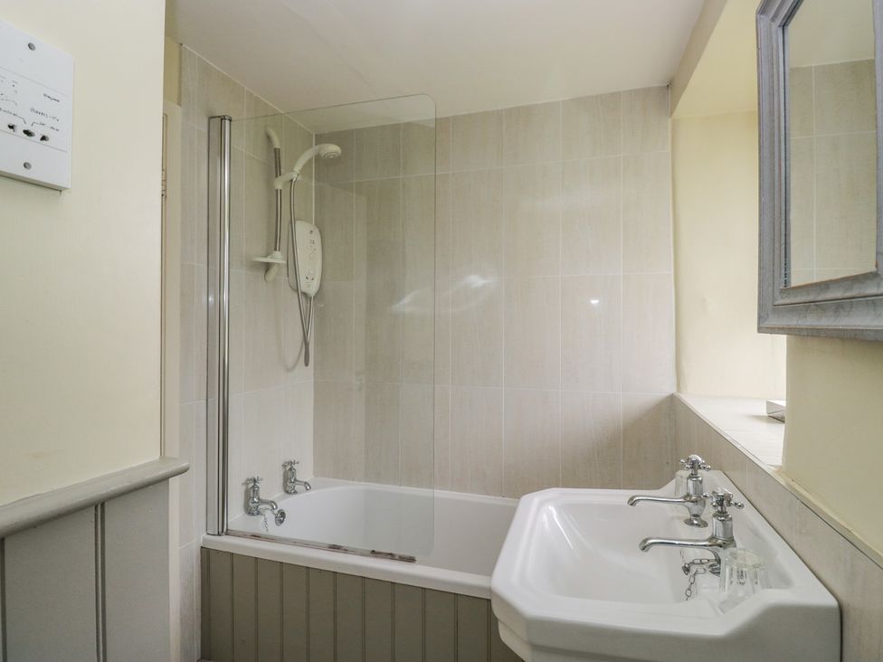 A bathroom with a shower and bathtub at The Laundrymaid's Cottage Cartmel