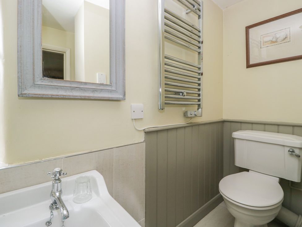 A bathroom with a toilet and wash basin at The Laundrymaid's Cottage in Cartmel
