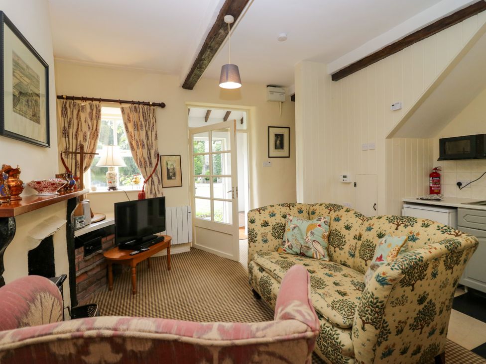 A living room with a sofa and television at The Laundrymaid's Cottage in Cartmel