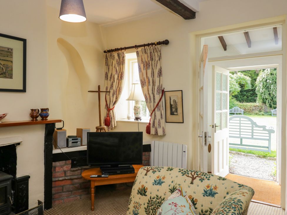 A living room with a TV and a sofa at The Laundrymaid's Cottage in Cartmel