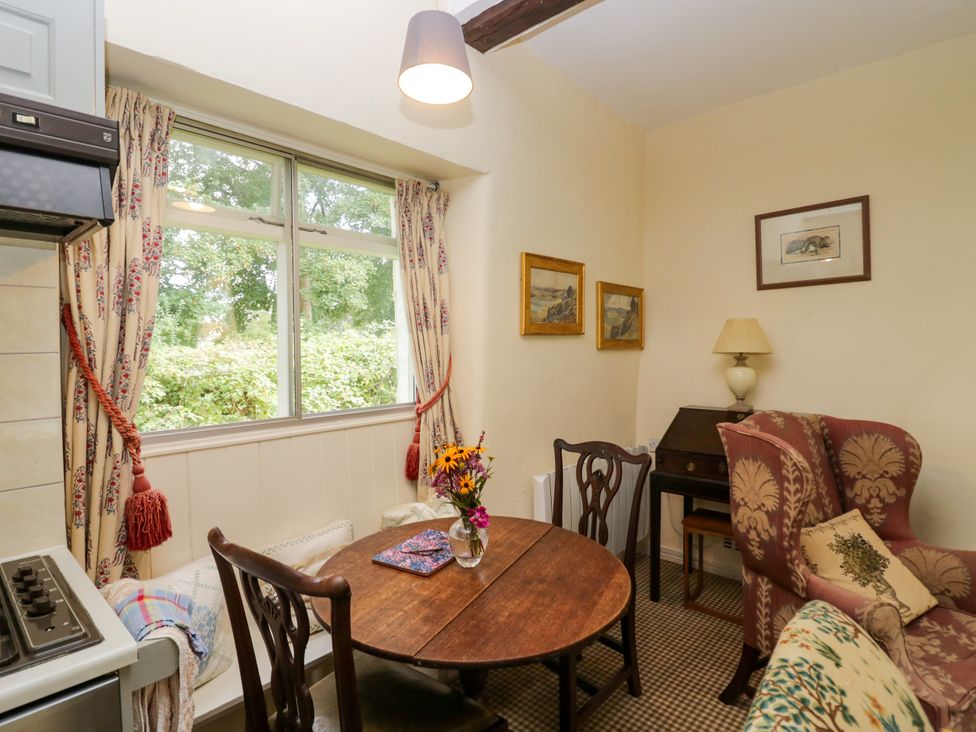 A dining room with a table and chairs at The Laundrymaid's Cottage in Cartmel