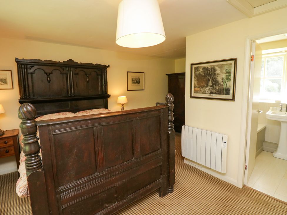 A bedroom with a bed and nightstands at The Laundrymaid's Cottage in Cartmel