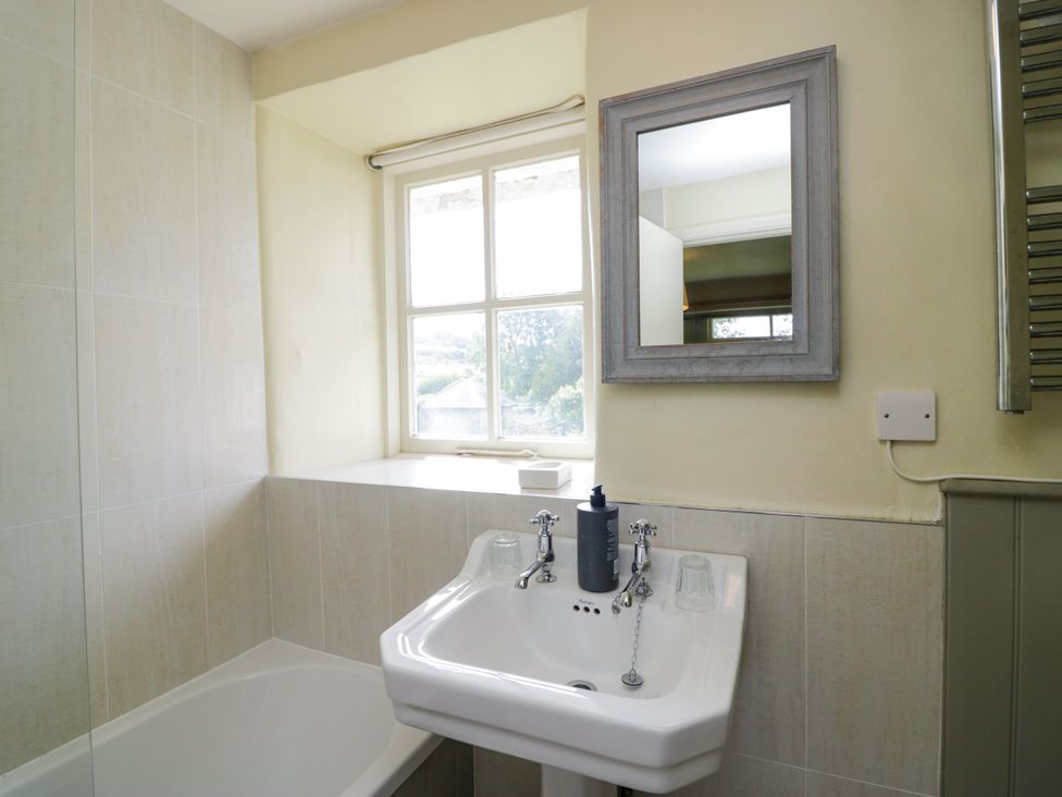 A bathroom with a sink and window at The Laundrymaid's Cottage in Cartmel
