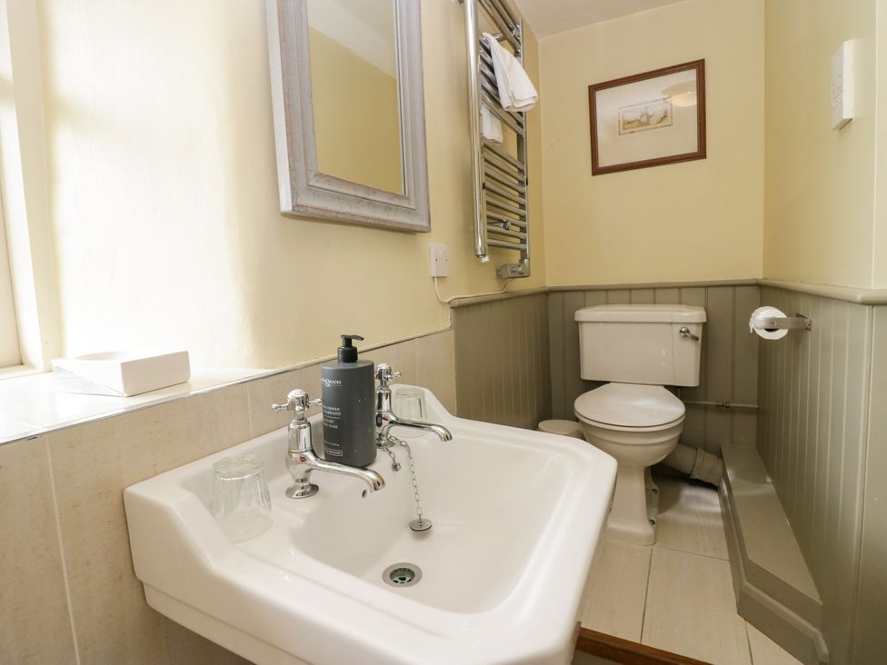 A bathroom with a sink and a toilet at The Laundrymaid's Cottage in Cartmel