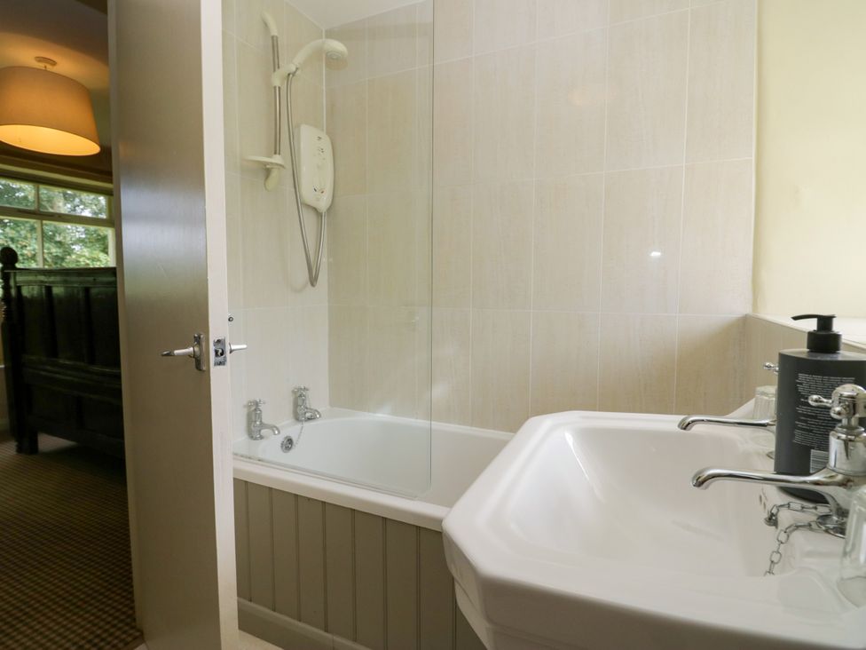 A bathroom with a bathtub and sink at The Laundrymaid's Cottage in Cartmel