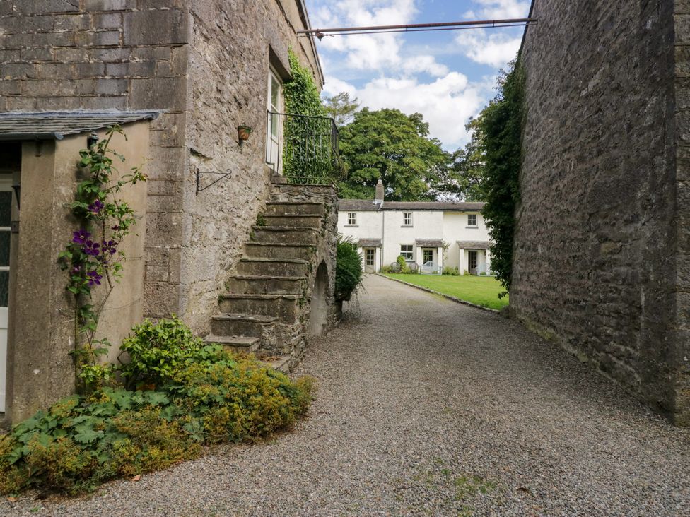 A garden with a gravel pathway and stairs at The Laundrymaid's Cottage in Cartmel