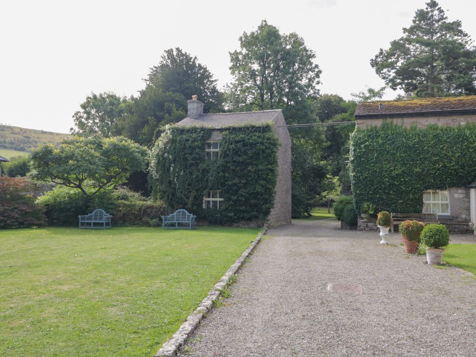 A garden with a house and seating area at The Laundrymaid's Cottage in Cartmel