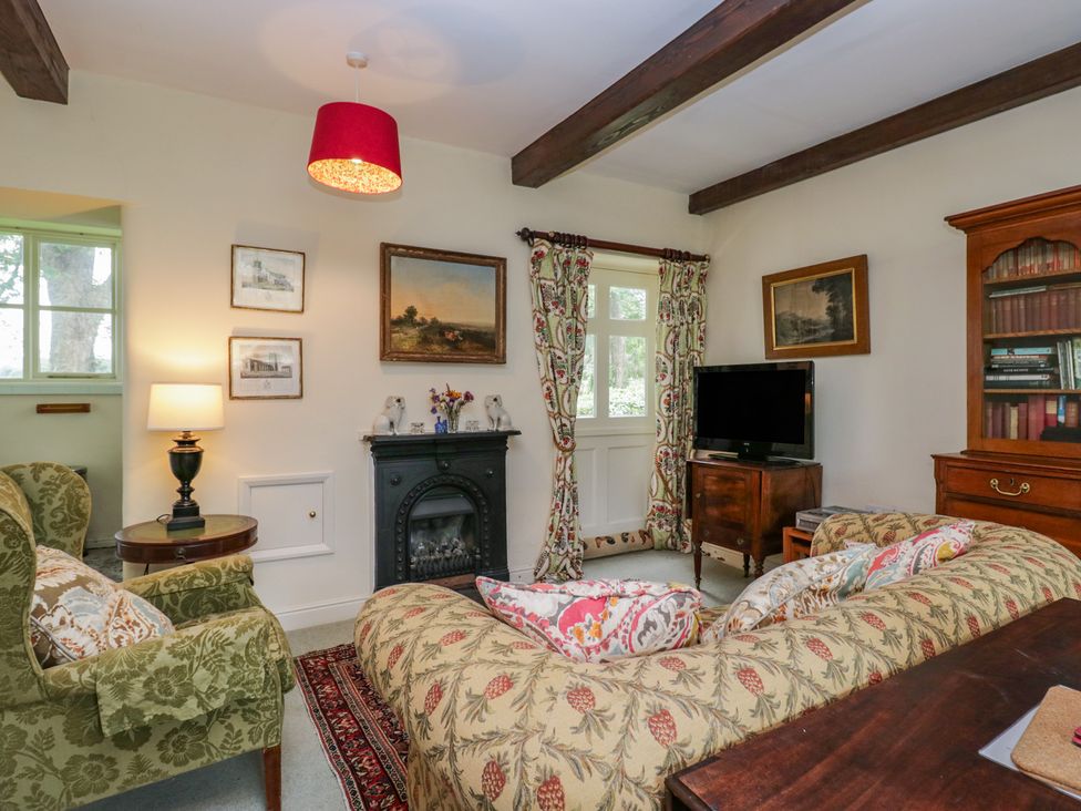 A living room with a sofa and television at The Gameskeepers Cottage in Cartmel