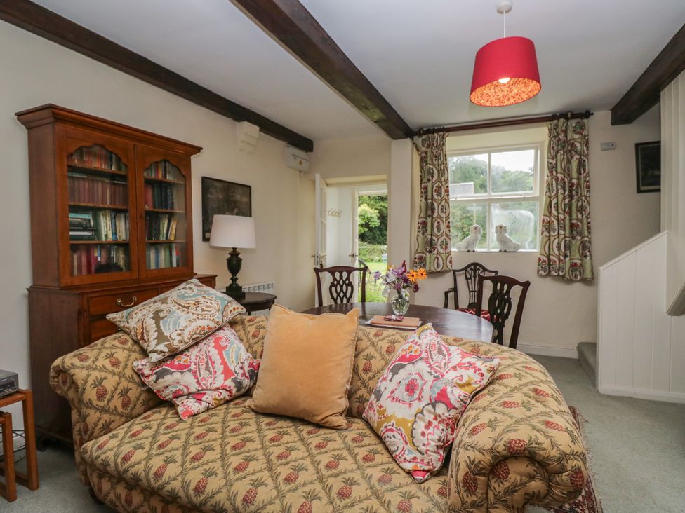A living room with a sofa and a table at The Gameskeepers Cottage in Cartmel