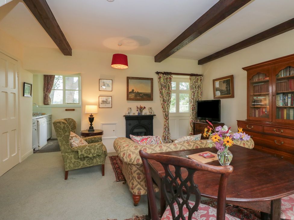 A living room with a sofa and a table at The Gameskeepers Cottage in Cartmel