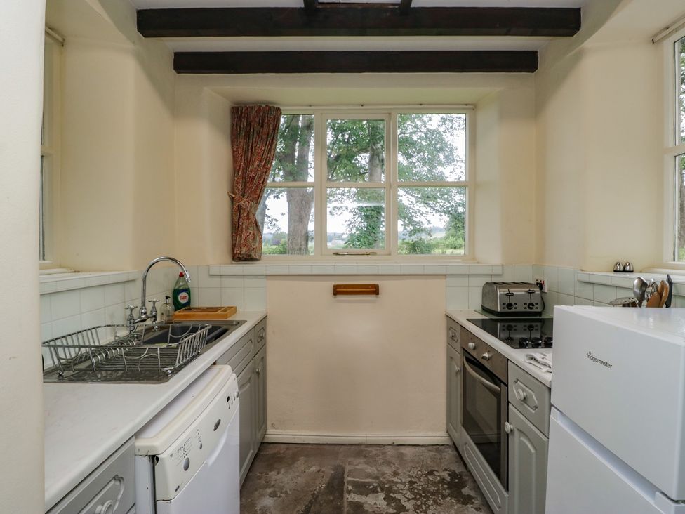 A kitchen with a sink, oven and dishwasher at The Gameskeepers Cottage in Cartmel