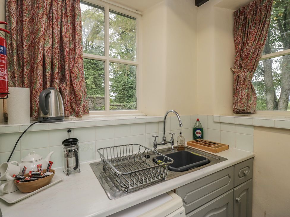 A kitchen with a sink and kettle at The Gameskeepers Cottage in Cartmel