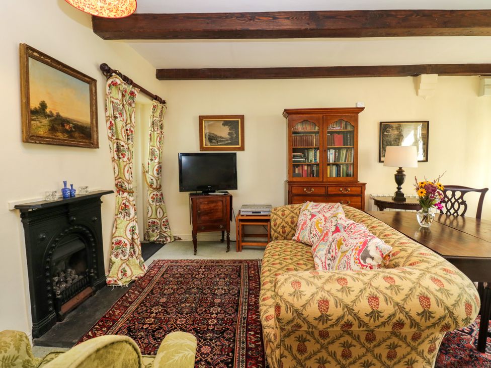 A living room with a sofa and a television at The Gameskeepers Cottage in Cartmel