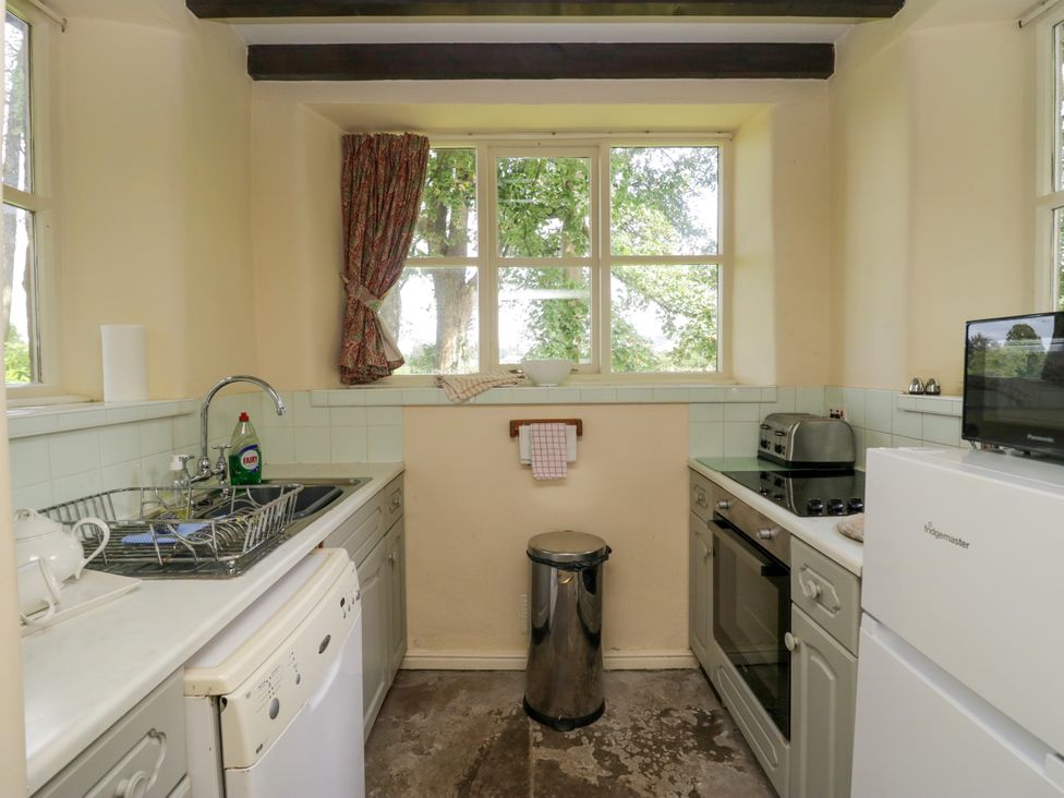 A kitchen with a sink and appliances at The Gameskeepers Cottage in Cartmel