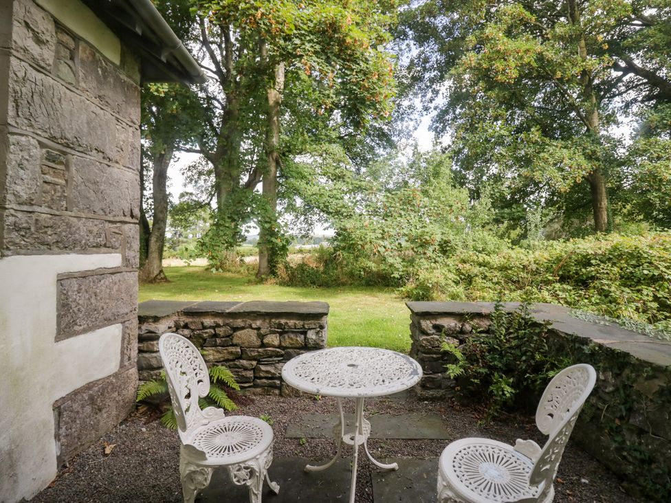 An outdoor seating area with a table and chairs at The Gameskeepers Cottage in Cartmel